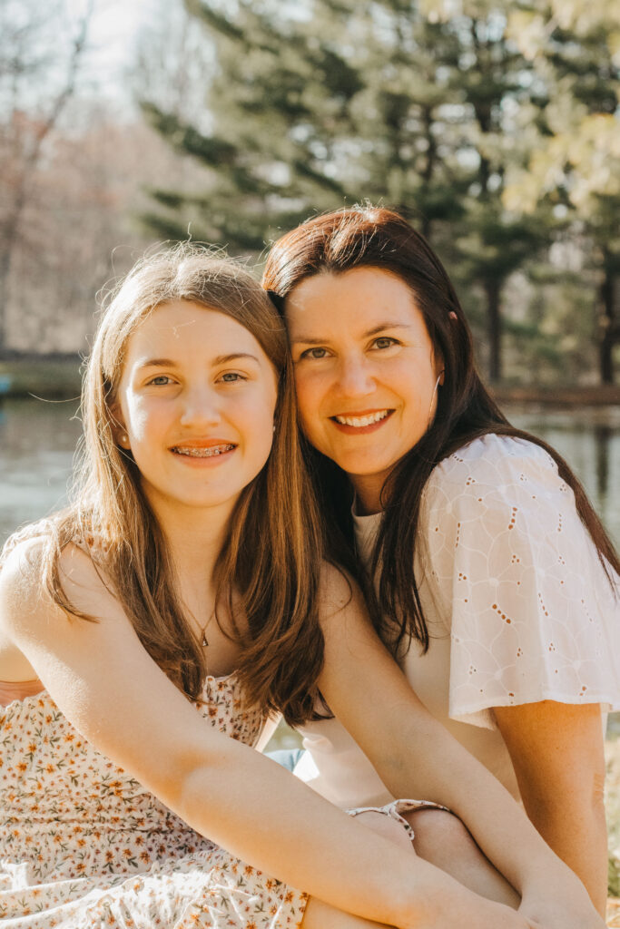 Mother and Daughter embrace at horse barn during rustic family photos in the Philadelphia subrubs