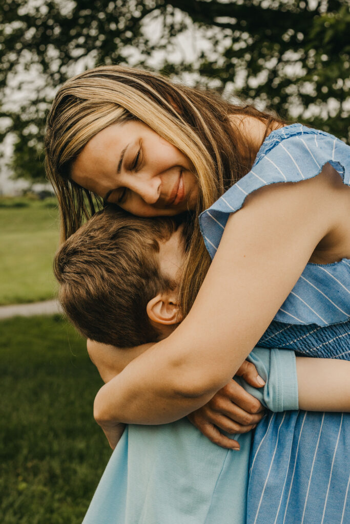 Mom leaning over to hug son tightly during Philadelphia family photo session