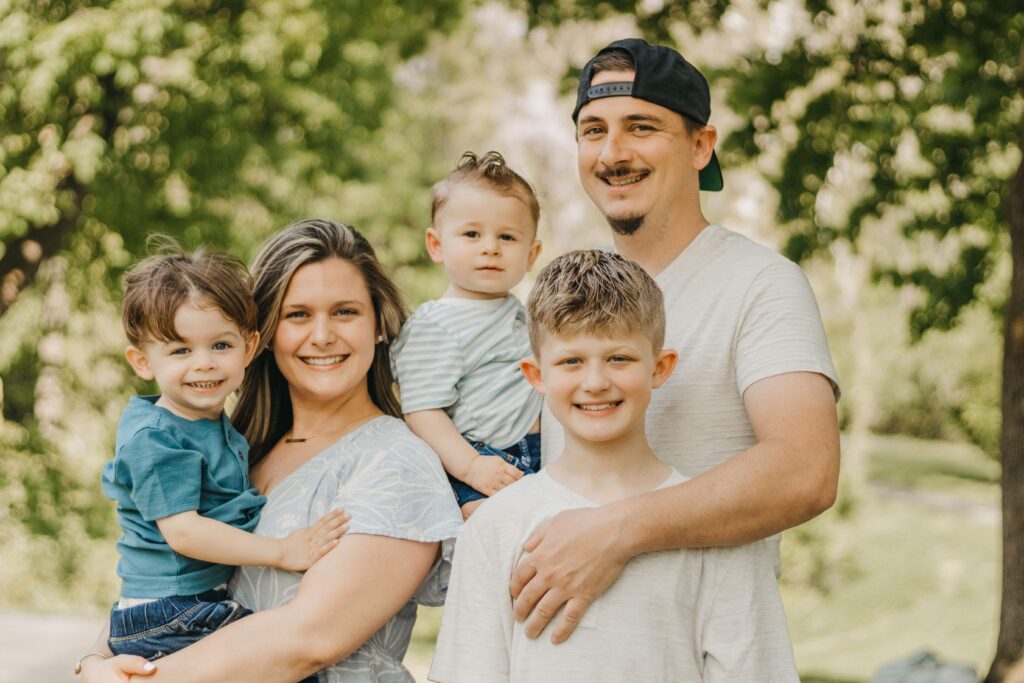 family poses and smiles at camera during philadelphia family photo session