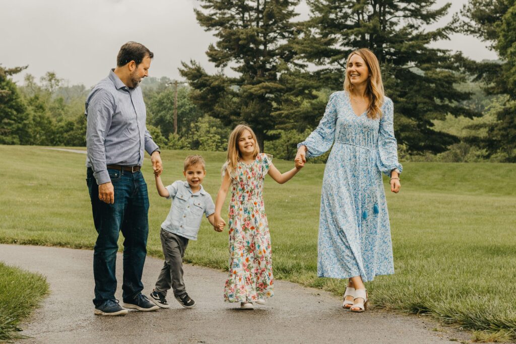 family of 4 talks and walks hand in hand during philadelphia family photo session