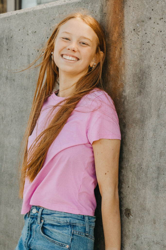 Teenage girl leans against wall at dock of Marsh Creek State Park during Mother Daughter photoshoot