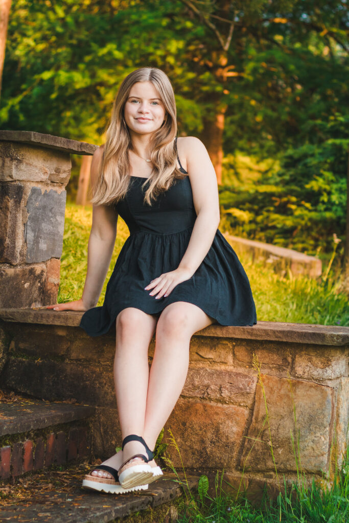 Addie sitting on a park bench, looking serene and lovely as the sun sets