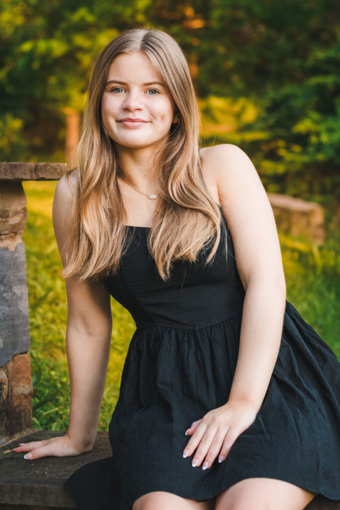 Addie sitting on a park bench, looking serene and lovely as the sun sets