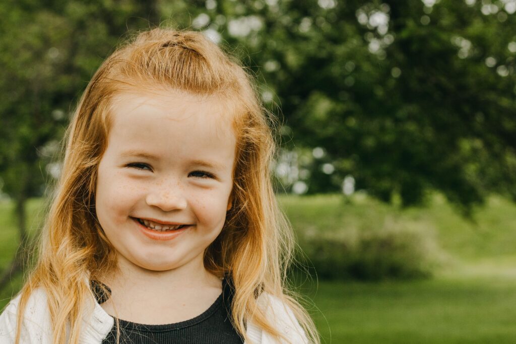 girl smiles under tree in Charlestown Township Park during a fundraiser